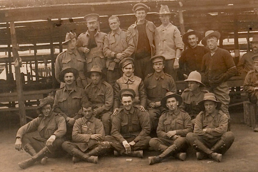 More than a dozen Australian World War I troops in a sepia photo from the war.