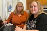 Deborah and Isabella Hollis sit in a kitchen with a laptop.