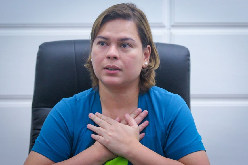 Sara Duterte with her hands folded over her chest 