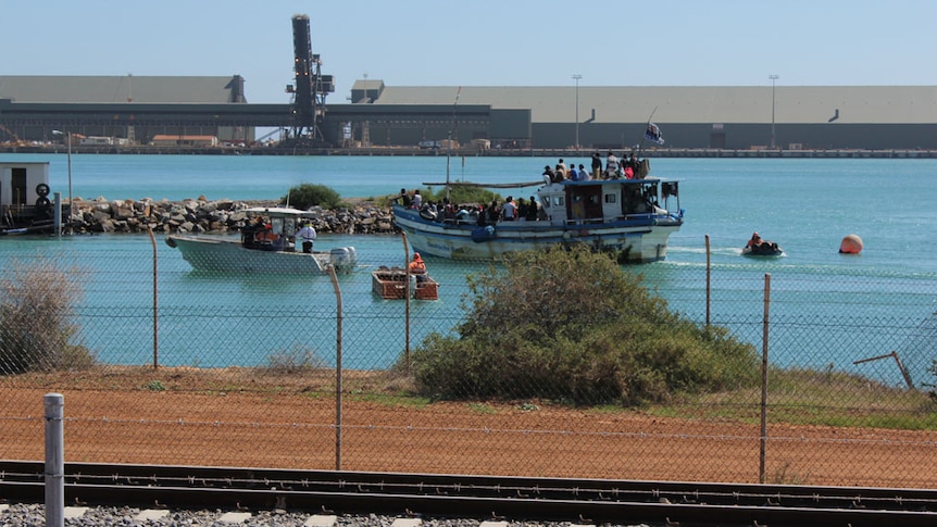 A boat carrying asylum seekers is shepherded into Geraldton's harbour