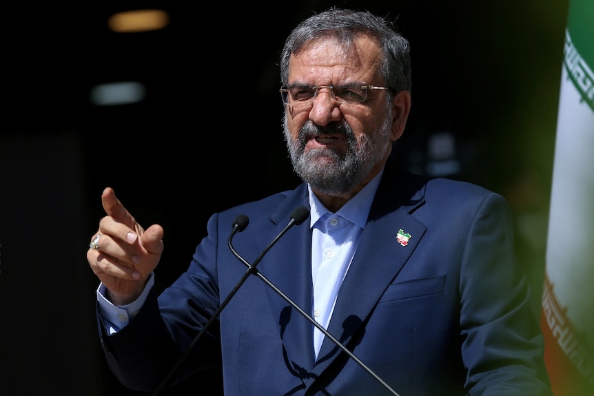 Presidential candidate Mohsen Rezaei speaks from a podium before the last election debate in Tehran.