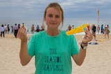 Anna Jane Linke holds up litter at Bondi Beach