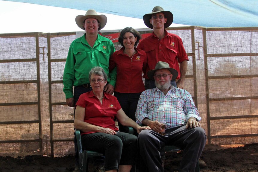 five people in a cattle yard