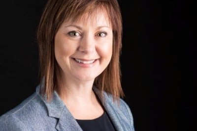 A woman with brown hair wearing a blazer