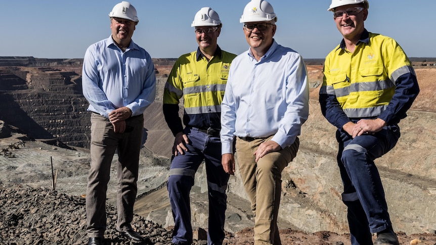 Four men wearing hard hats, including Prime Minister Scott Morrison, at a gold mine.