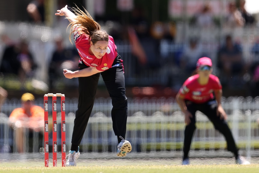 Lauren Cheatle bends over after she bowls a ball.