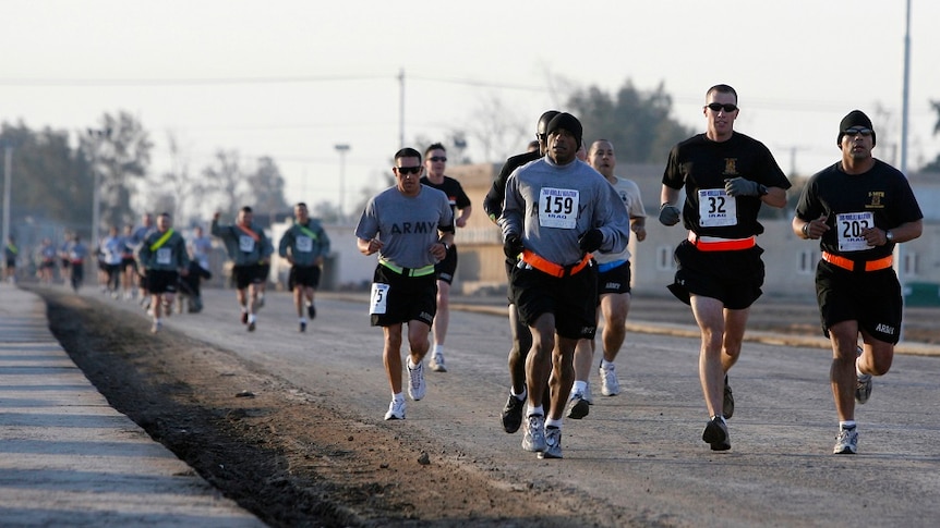 American soldiers run on a road near Baghdad.