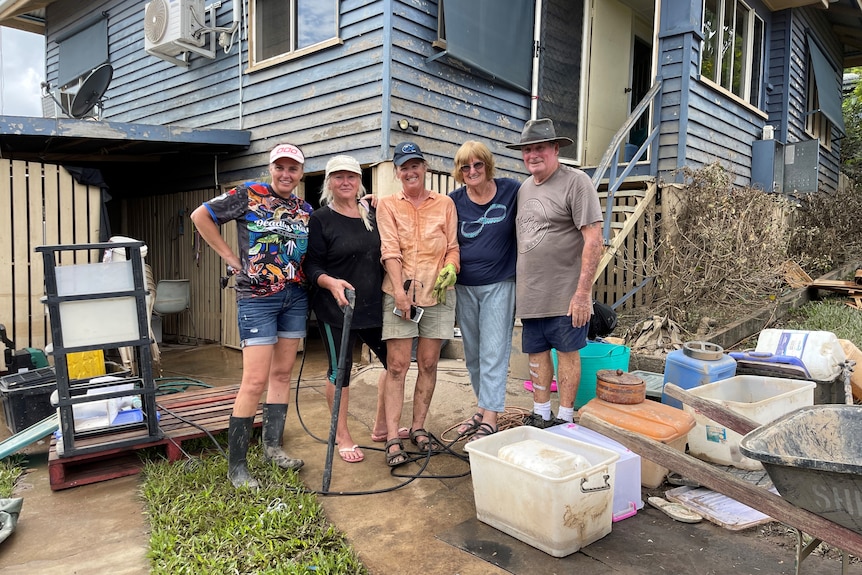 group of people clean up flooded home