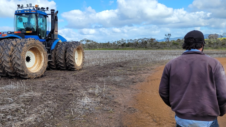 A tractor sits idle on an unsown paddock.