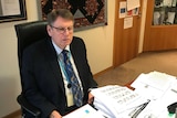 A man sits at a desk