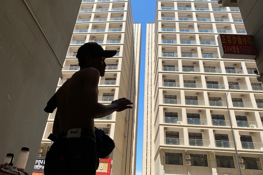 Silhouette of a person in front of a complex in Chinatown. 