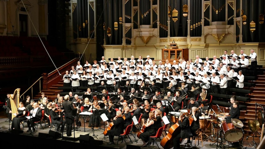 The Sydney University Graduate Choir and Orchestra with conductor Christopher Bowen on stage at Sydney Town Hall.