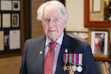 Veteran Bruce Robertson stands with his medals.