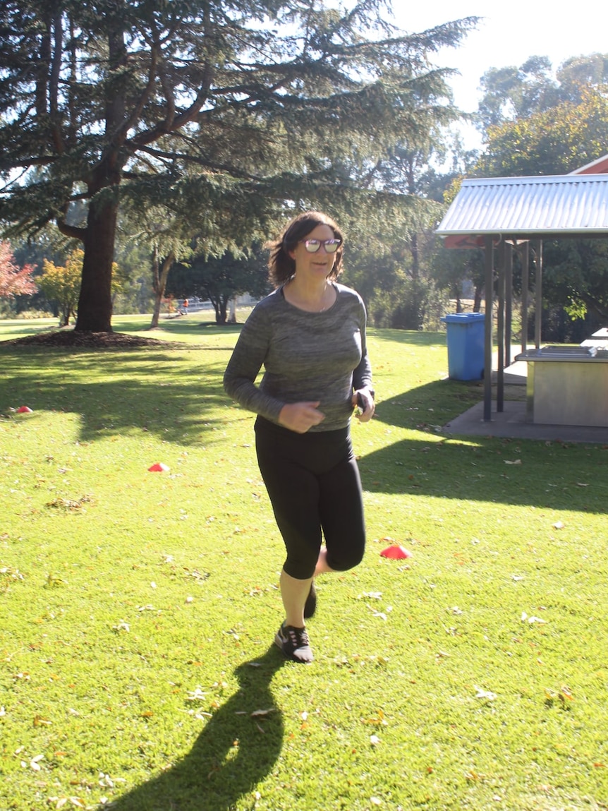 42-year-old Claire Scott, wearing glasses, runs at the Bathurst parkrun course
