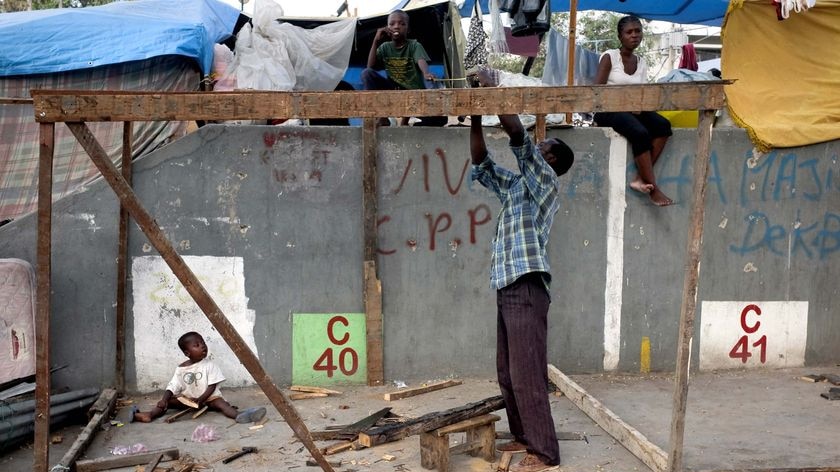 A Haitian man building a makeshift shelter after the earthquake