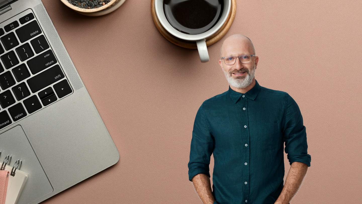 laptop and coffee on the left, a man with glasses on the right