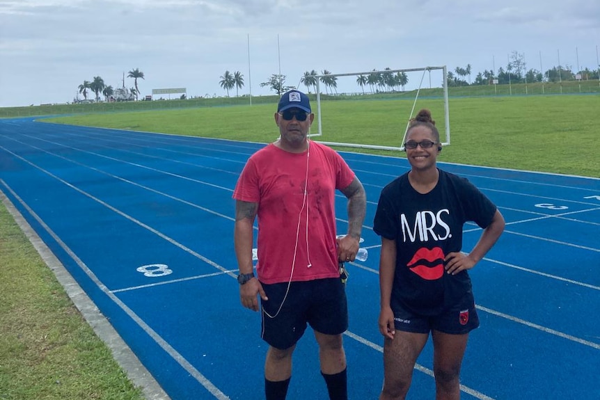 Joanne standing with her father Adam Butler on a running track 