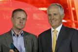 Australian of the Year David Morrison on stage with his award with Prime Minister Malcolm Turnbull