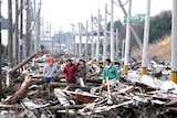 Ruined: people make their way through a street clogged with tsunami debris in Sendai.