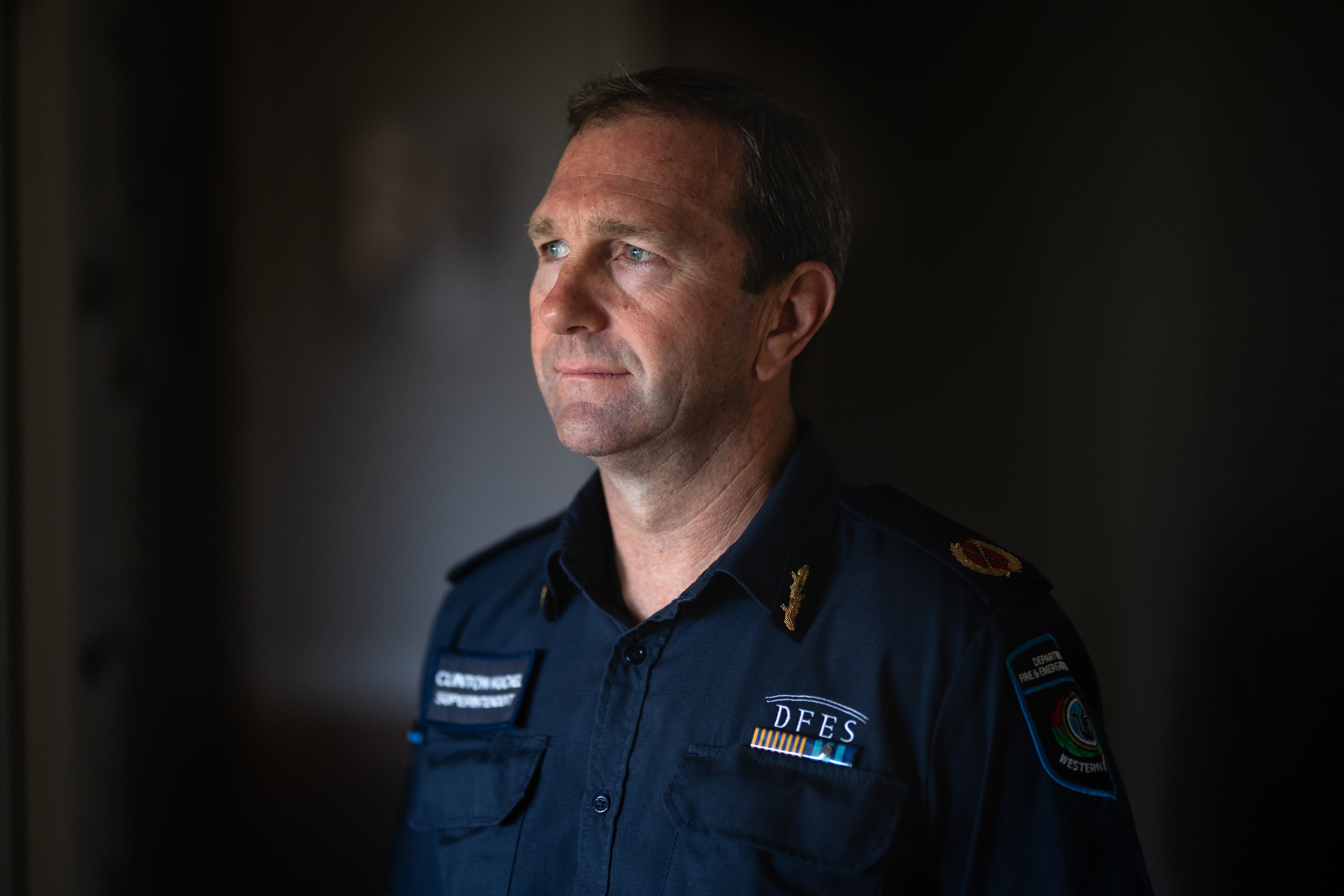 Retrato temperamental de um homem parado em um corredor mal iluminado