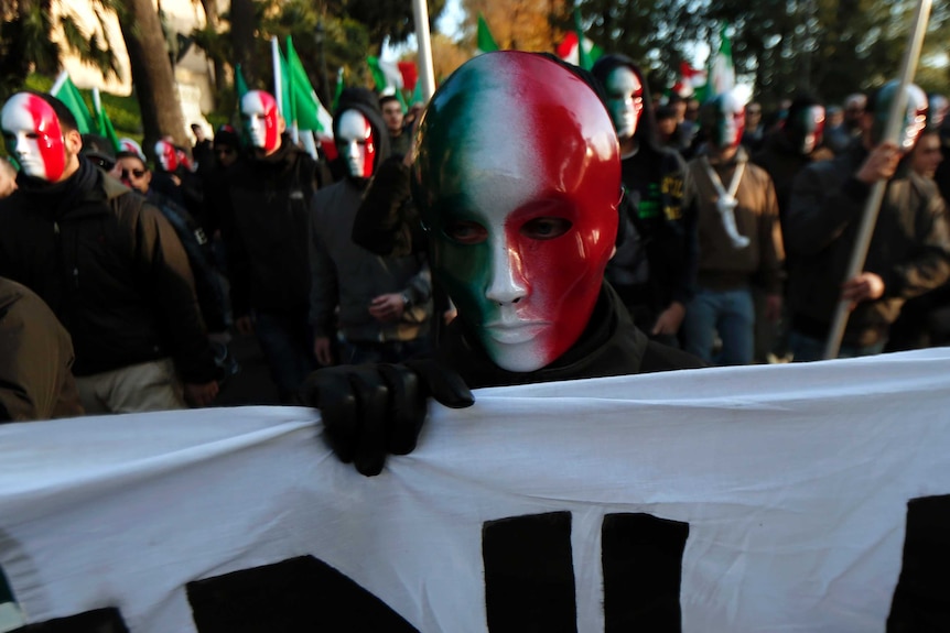 A member of Casapound far-right organisation wears a mask in the colours of the Italian flag.