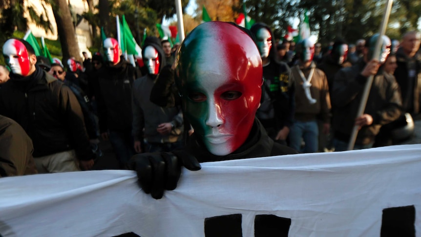 A member of Casapound far-right organisation wears a mask in the colours of the Italian flag.