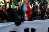 A member of Casapound far-right organisation wears a mask in the colours of the Italian flag.