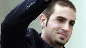Wade Robson, as an adult, holds his hand up in a 'peace' gesture.