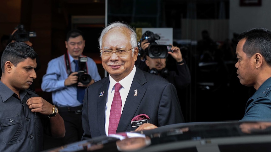 Najib Razak walking towards his car after attending a parliament session in Kuala Lumpur.