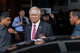 Najib Razak walking towards his car after attending a parliament session in Kuala Lumpur.