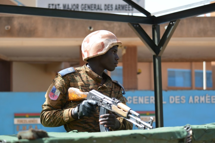 soldier with a gun and pink helmet in Burkina Faso