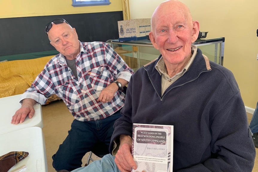 two older men pose for photo.