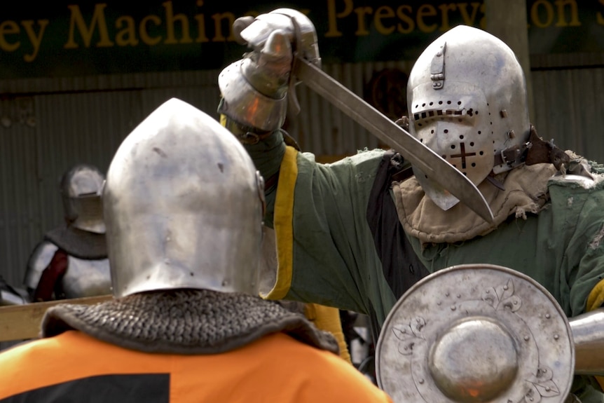 A Buhurt fighter wields a heavy , curved sword called a falchion during a bout.