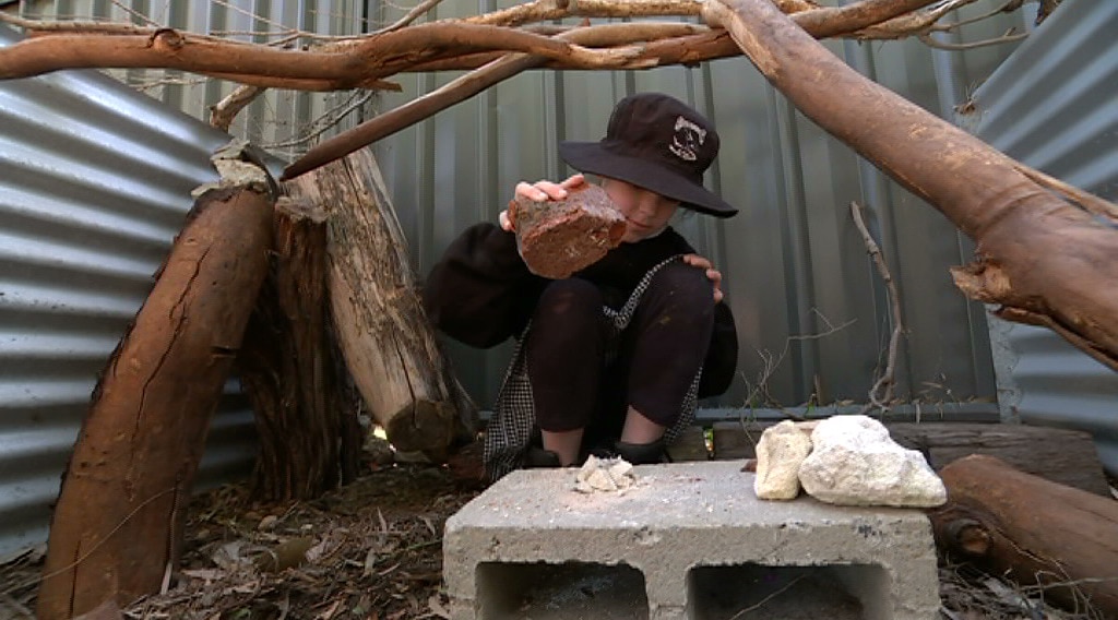 An unidentified child plays at North Fremantle Primary School in a nature playground.