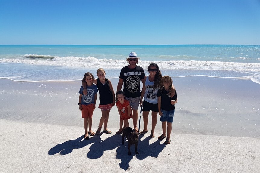 The Willett family pose for a photo on the beach.