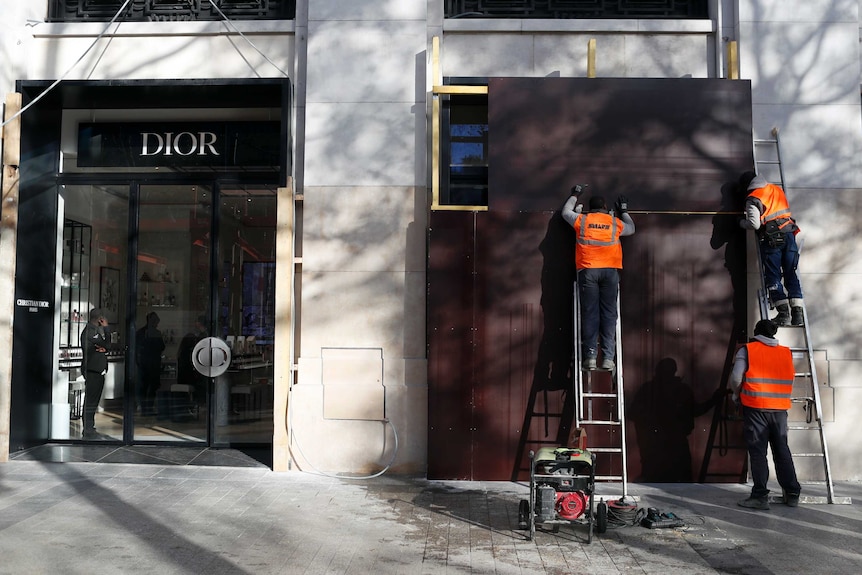 A Parisian Dior store windows are reinforced with metal sheets after protests on the famed Champs Elysees