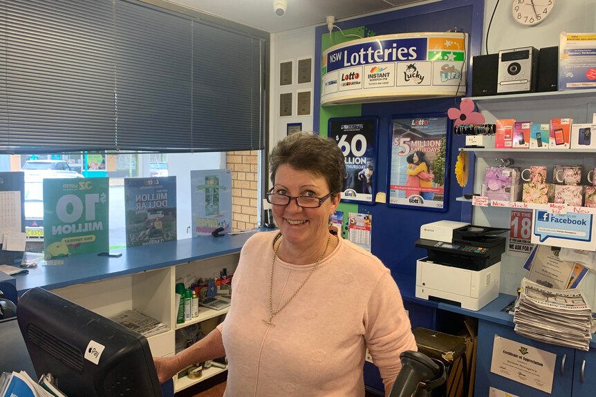 woman standing behind the counter of a newsagent 