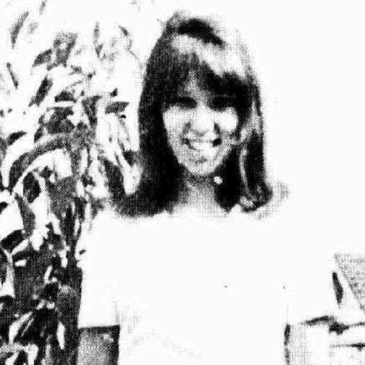 An old, grainy photo of a young woman.