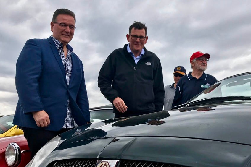 John Eren (left) and Daniel Andrews standing by a car.