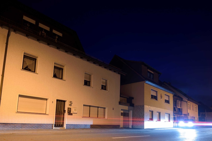 A car drives past a house in Wallenfels, southern Germany