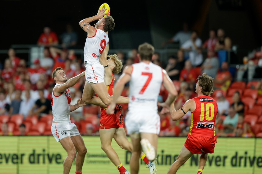 Will Hayward takes a mark above his head while soaring above a pack