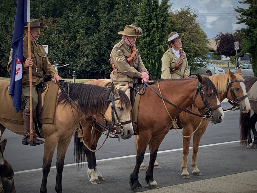 People in uniform on horseback at the a Remembrance Day service.