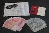 A map of Shanghai, a compass, a notebook, USB stick and cash in US and Chinese currency.