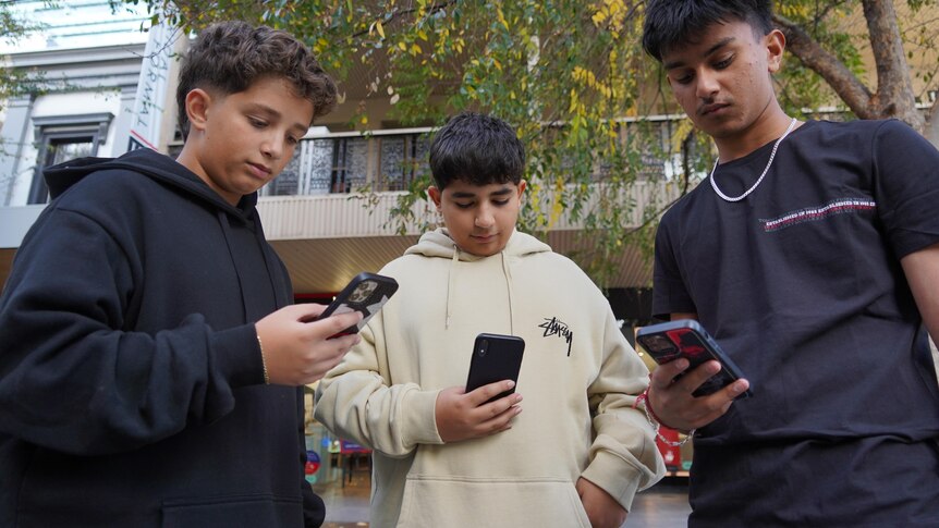 Teenagers use their phones.