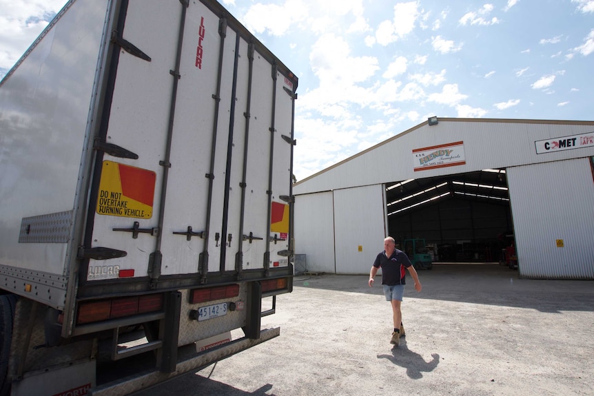Troy Hendy walks to the back of a truck in the transport yard.