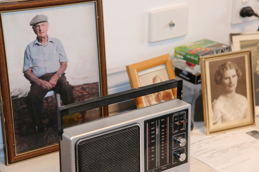 Photos and an old wireless on a bedside table