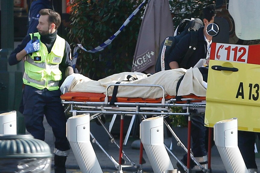 A victim is removed from the scene by medics in Brussels.