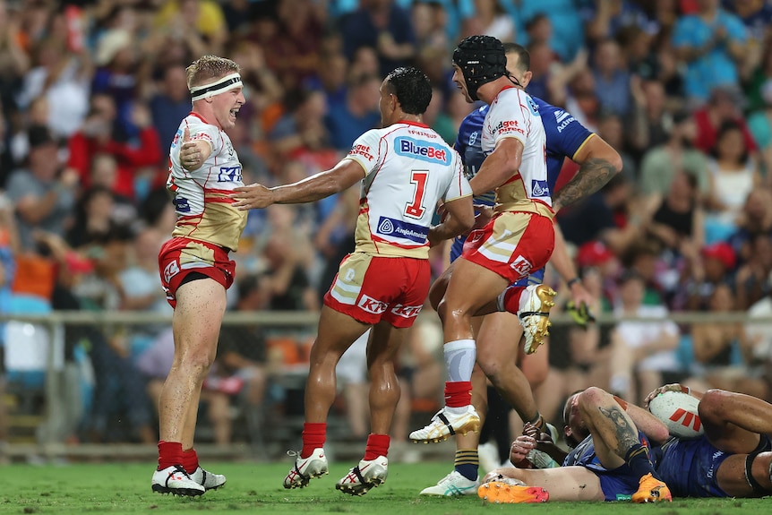 A rugby league player celebrates a try with his teammates 