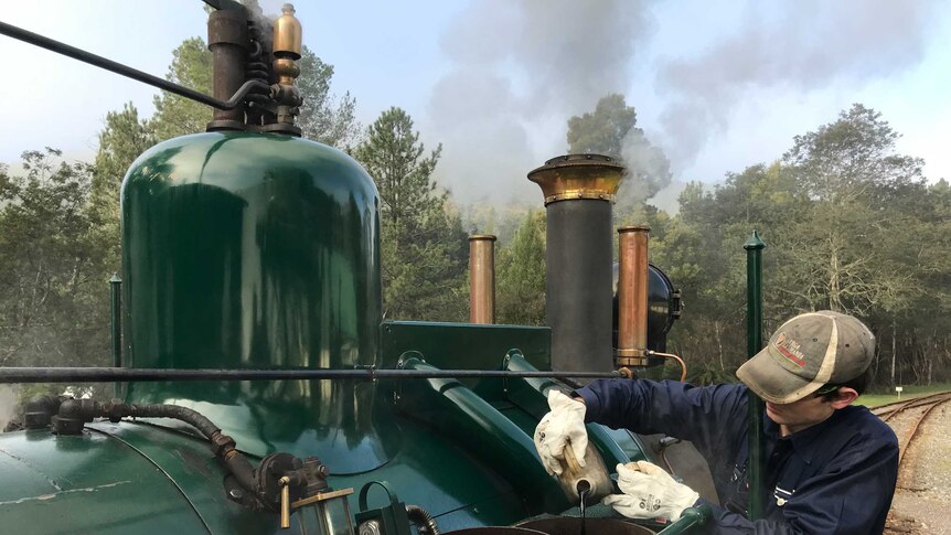 Brock adds oil into the train on its 35 km journey on the vintage rail line linking Queenstown to Strahan