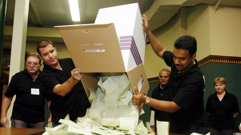 Electoral officials empty the first ballot box